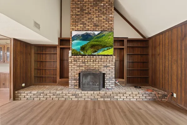 a living room with a fireplace and a walk in closet