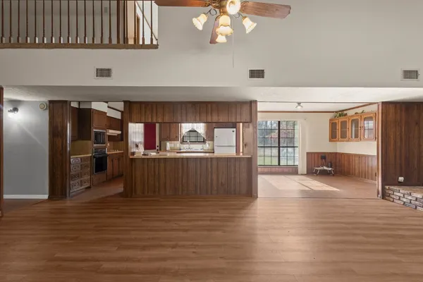 a kitchen with stainless steel appliances wooden floor and refrigerator