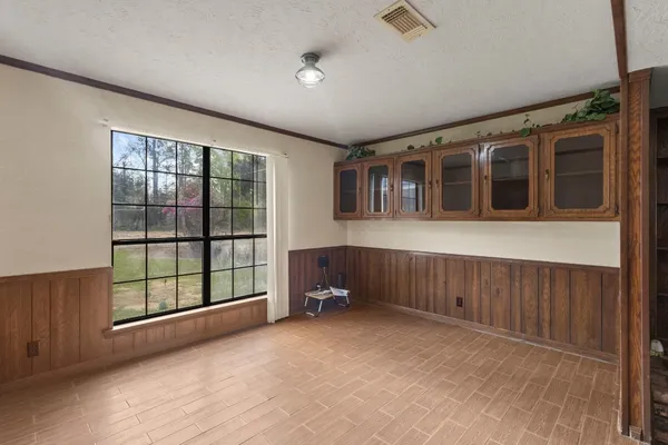 a view of an empty room with furniture and windows