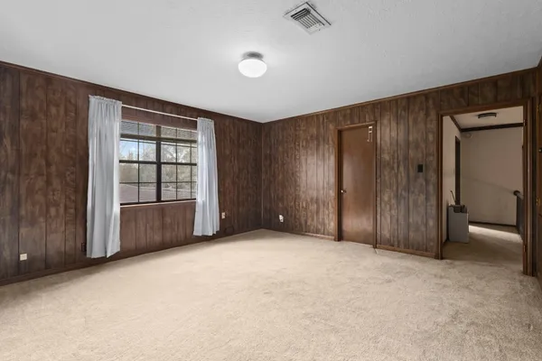 an empty room with windows and cabinet
