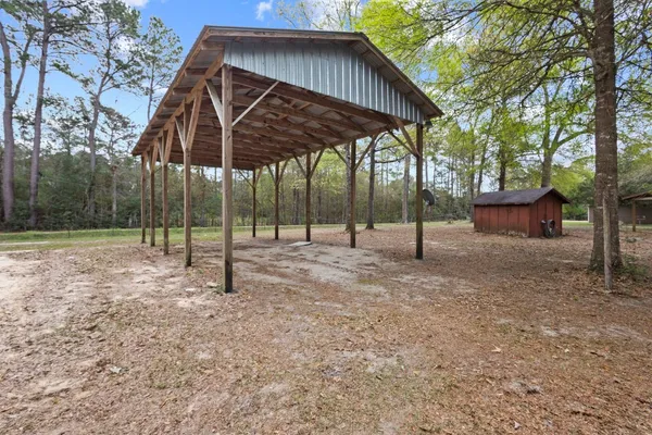 a view of a house with backyard and trees