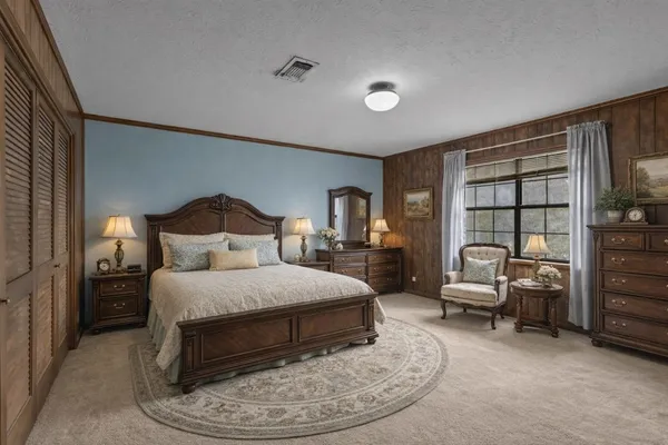 a bedroom with a bed and a large window