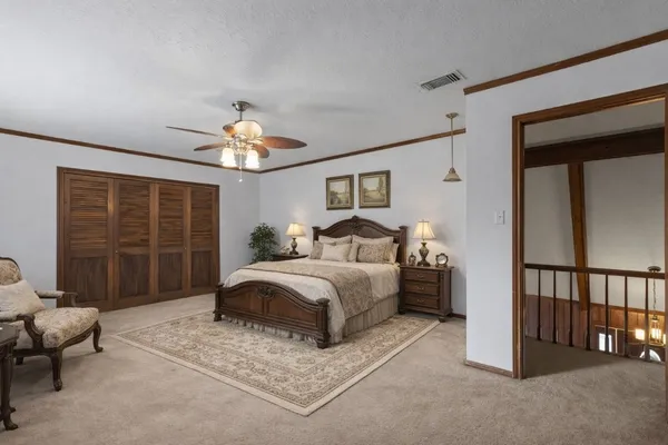 a spacious bedroom with a bed and a chandelier