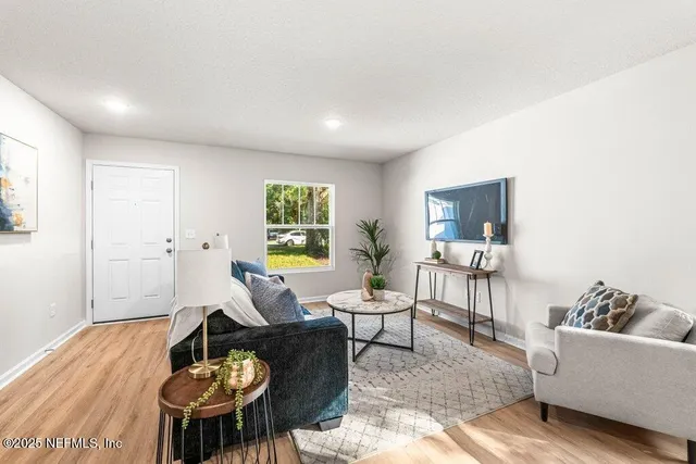 a living room with furniture and a wooden floor