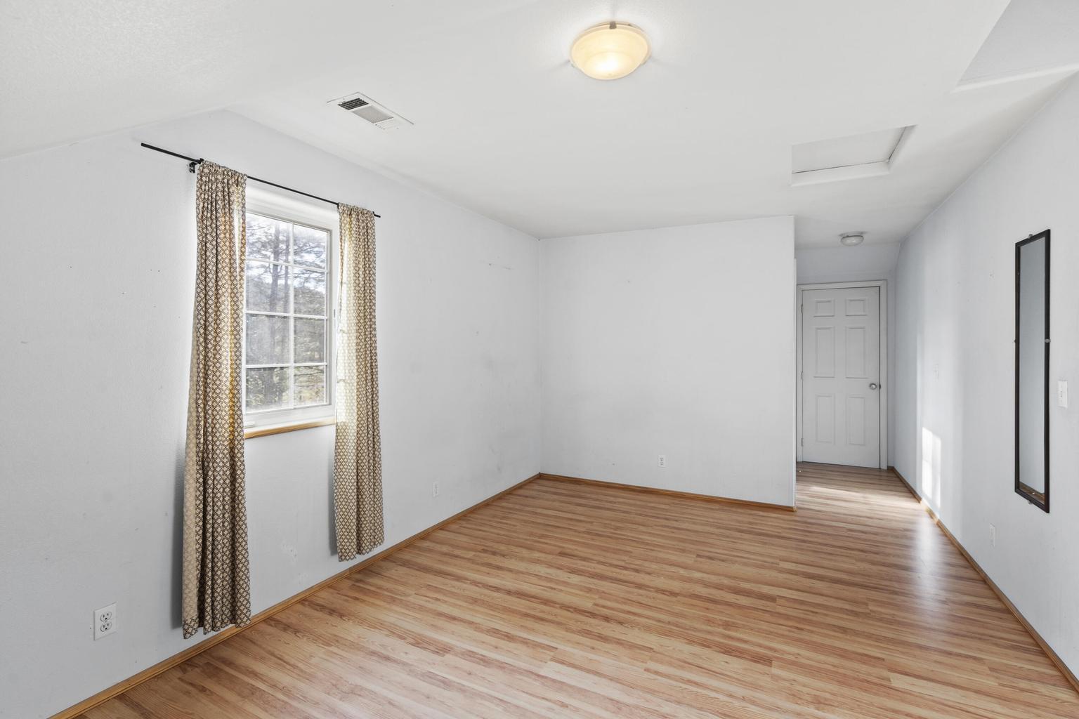 1190 Cedar Flat Road Williams, OR 97544 - Photo 18 of 45 a view of an empty room with wooden floor and a window