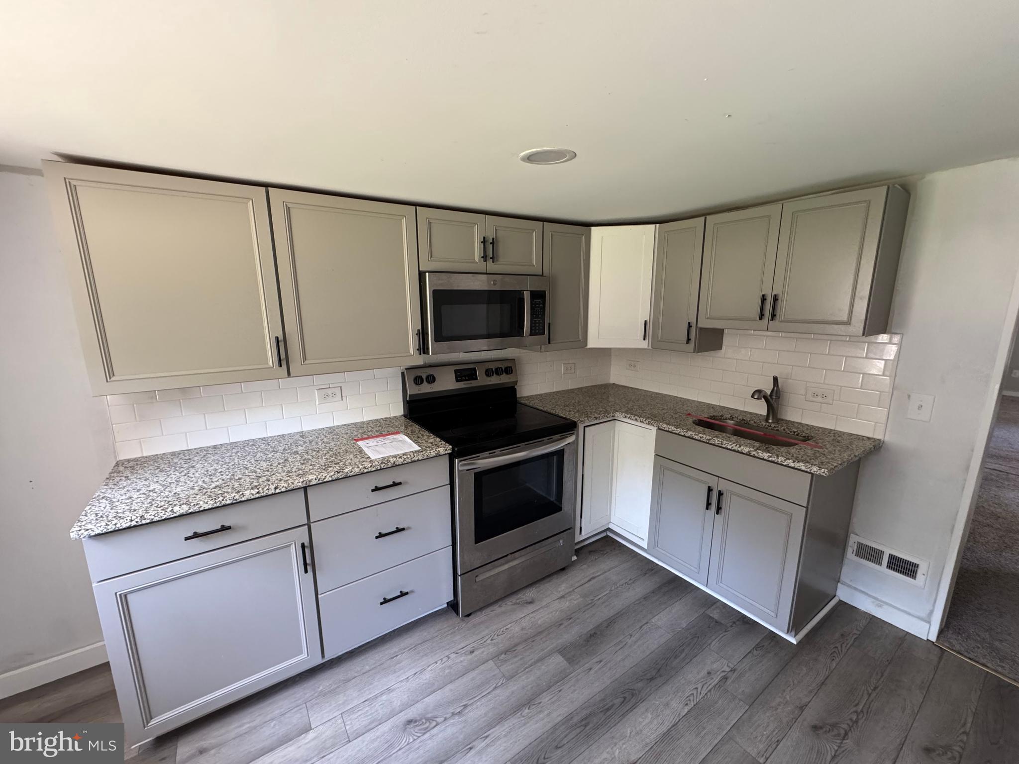 395 Tansboro Road Berlin, NJ 08009 - Photo 16 of 47 a kitchen with stainless steel appliances granite countertop a stove a sink and a microwave