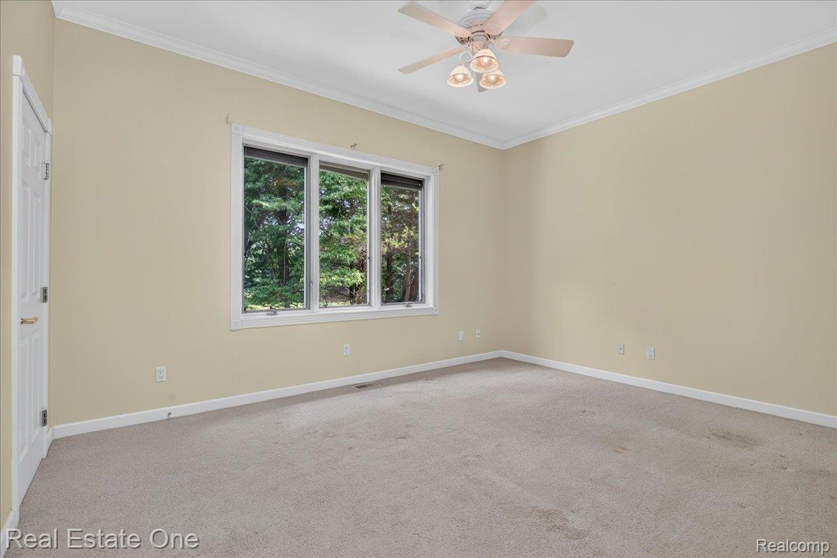 425 Courtney Road Leonard, MI 48367 - Photo 35 of 89 Room featuring a three-pane window, ceiling fan with integrated lighting, crown molding, and light-toned walls