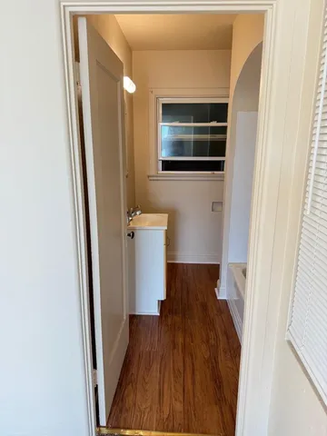 a view of a hallway with wooden floor and staircase