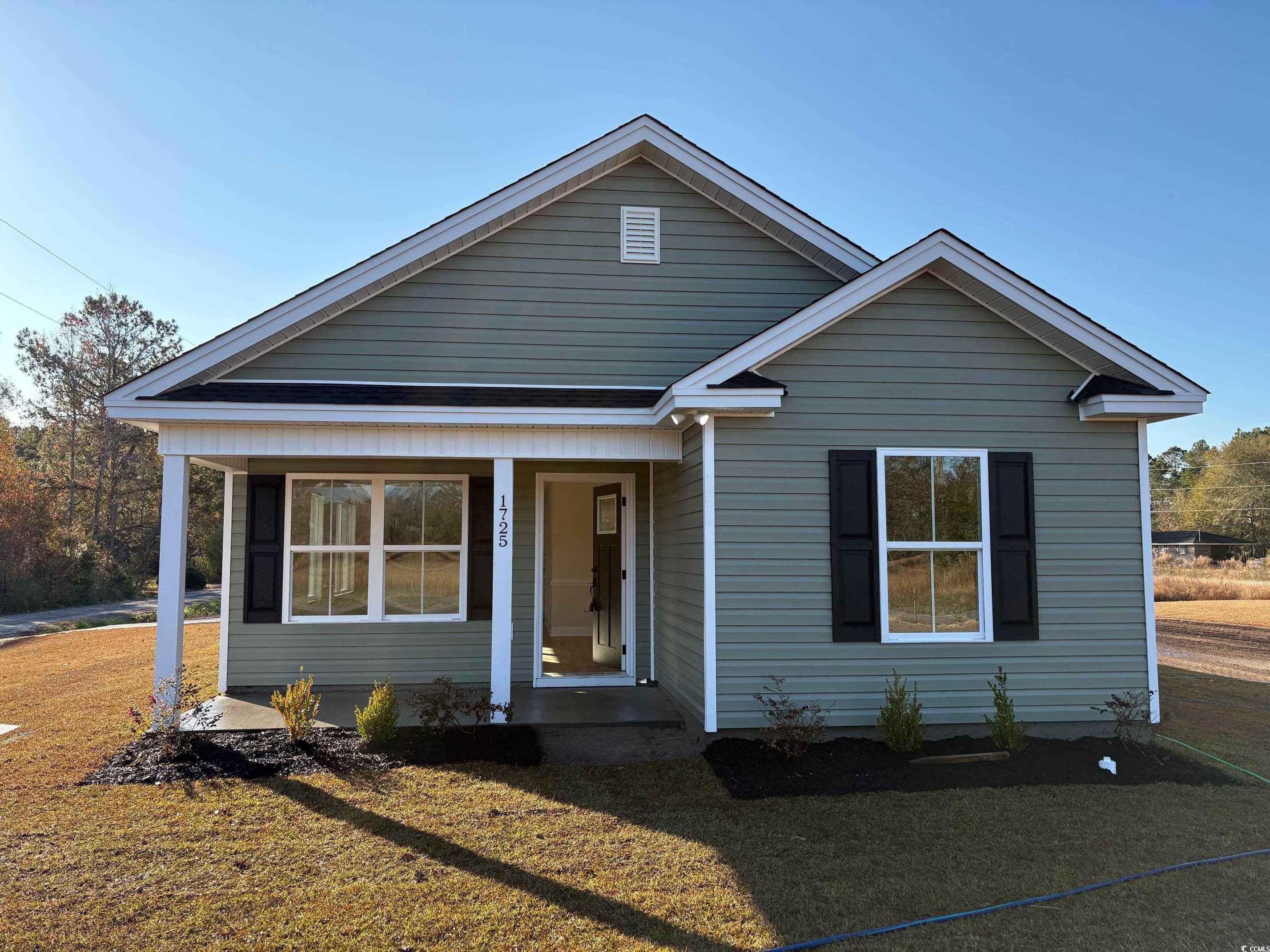 View of front of house with covered porch and a front yard