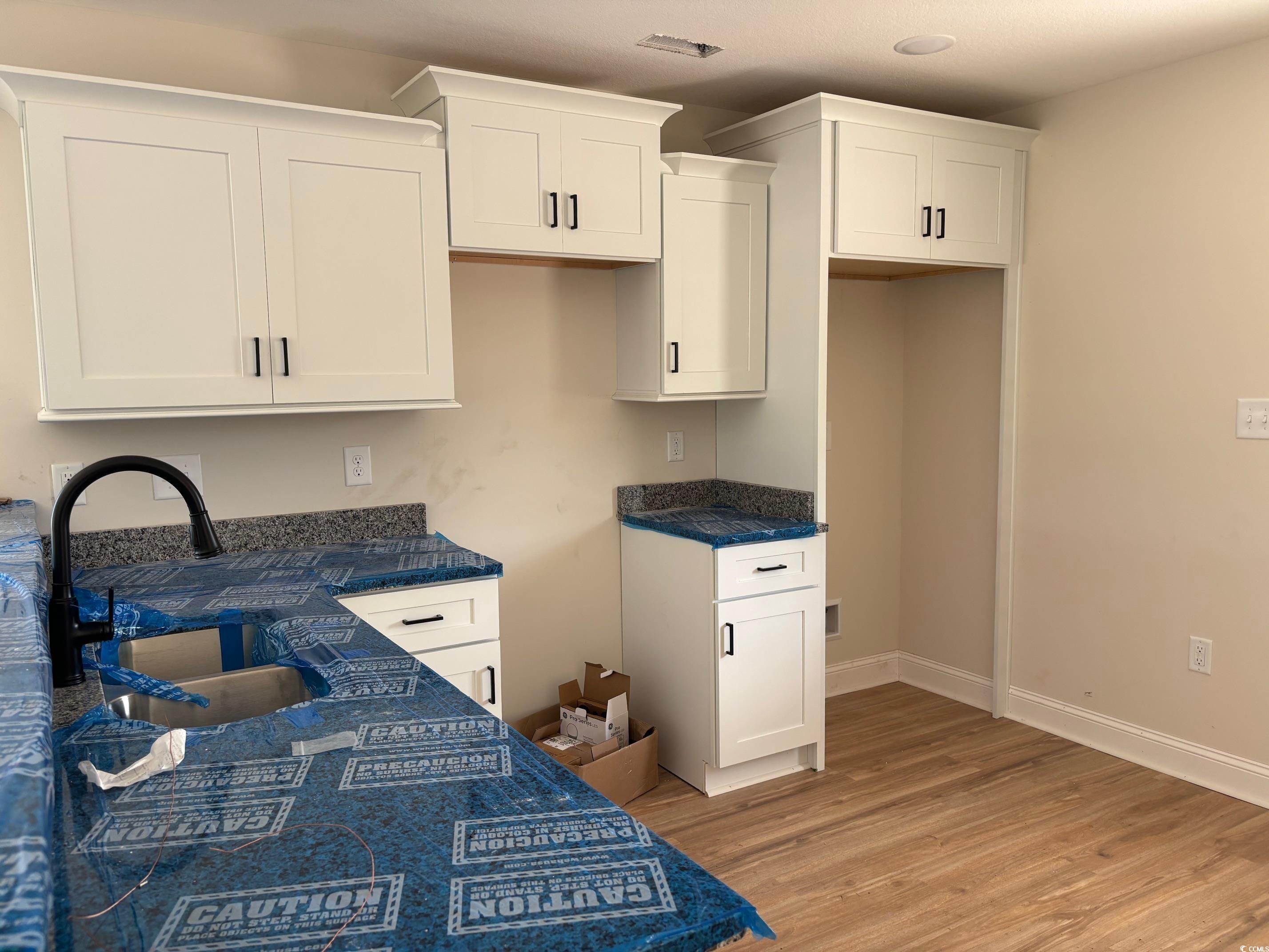 1721 Southern Crest Drive Loris, SC 29569 - Photo 8 of 16 Kitchen with white cabinets, light wood-type flooring, and dark stone countertops