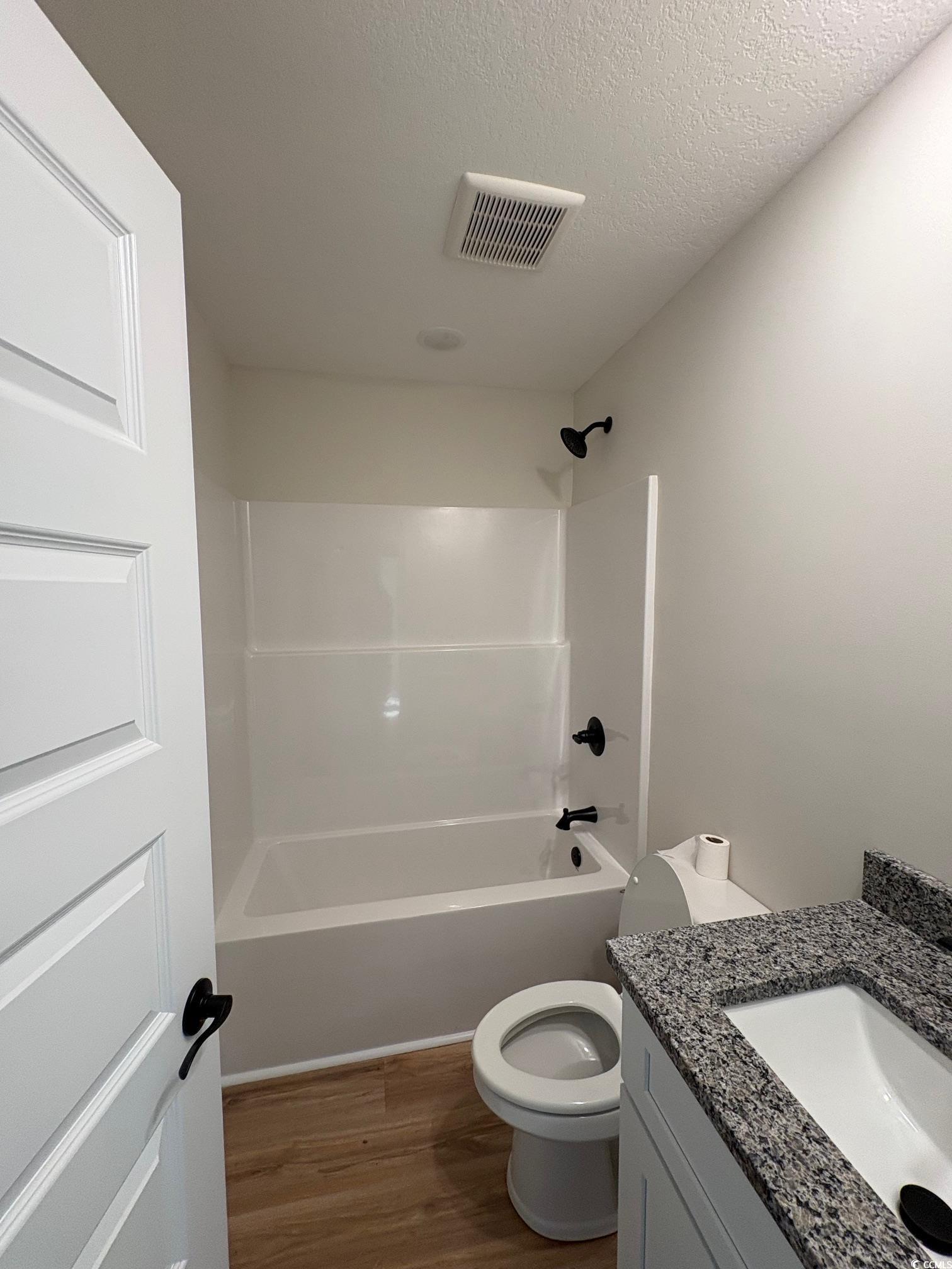 1721 Southern Crest Drive Loris, SC 29569 - Photo 10 of 16 Bathroom with shower / washtub combination, dark wood-style flooring, vanity, and a textured ceiling