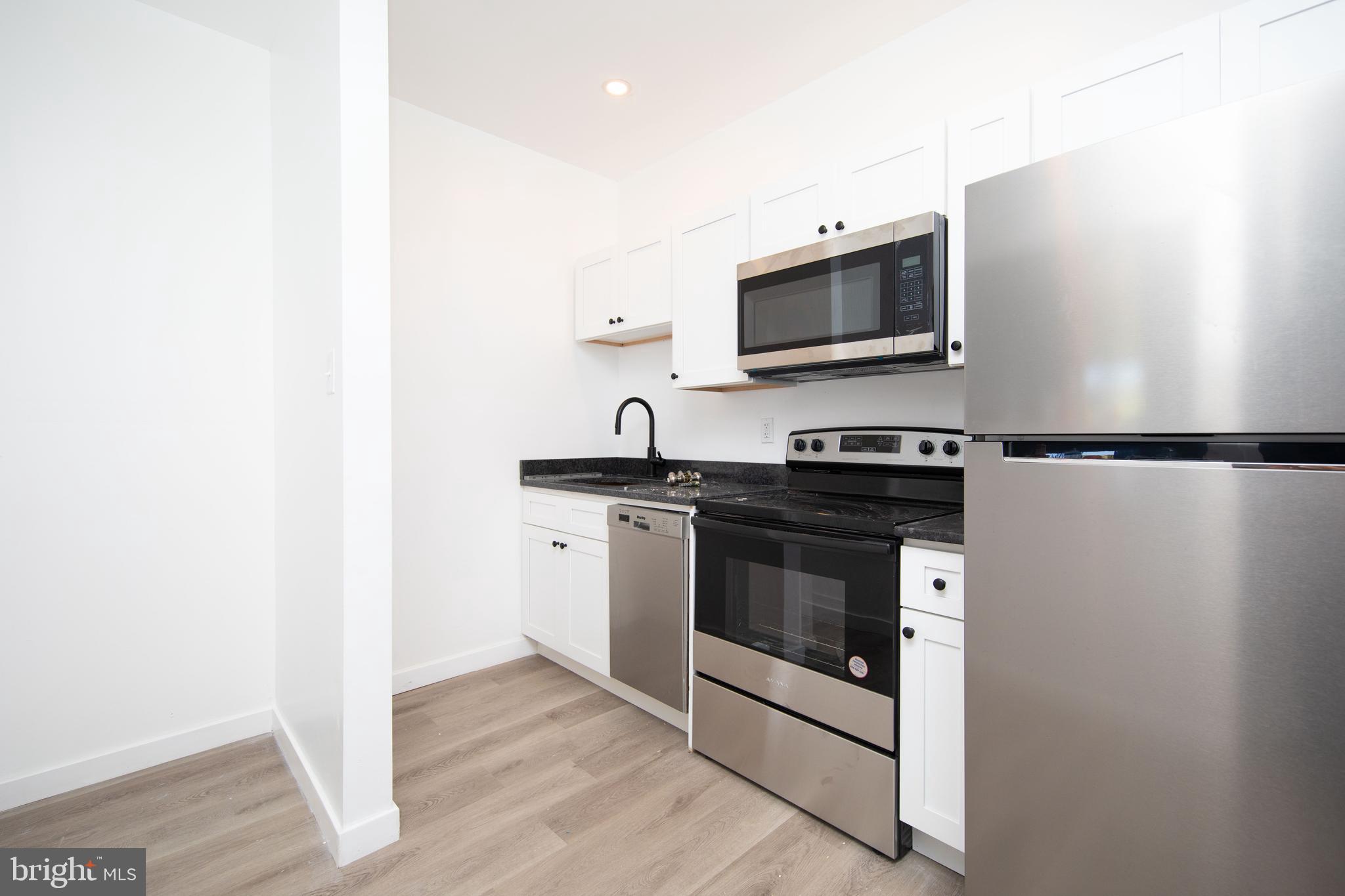 1841 North 33rd Street Philadelphia, PA 19121 - Photo 16 of 29 a kitchen with stainless steel appliances a stove microwave and sink