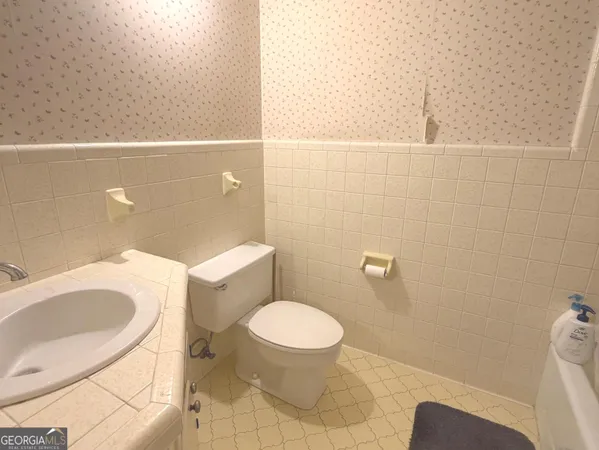 a white toilet sitting next to a bathroom sink