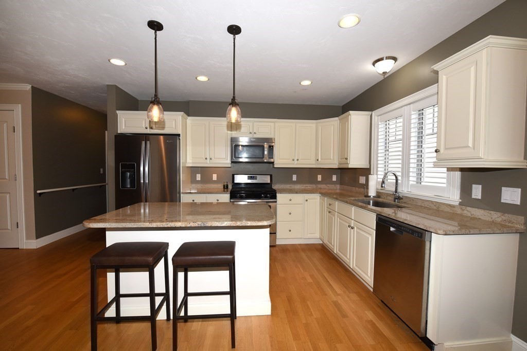 2 Mariner's Drive, Unit 2 (AKA 66) Marshfield, MA 02050 - Photo 2 of 41 a kitchen with stainless steel appliances granite countertop a refrigerator a sink dishwasher a stove and white cabinets with wooden floor