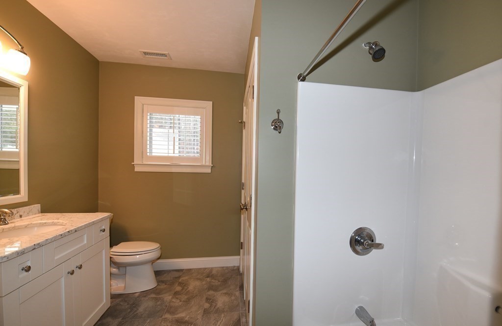 2 Mariner's Drive, Unit 2 (AKA 66) Marshfield, MA 02050 - Photo 32 of 41 a bathroom with a granite countertop toilet a sink and a mirror