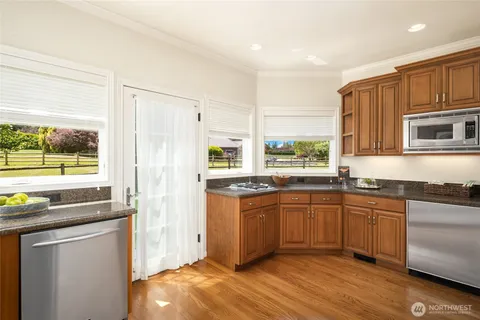 a kitchen with stainless steel appliances granite countertop a stove a sink and a refrigerator