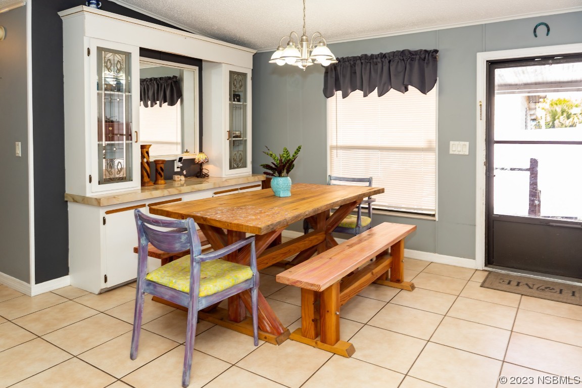 106 Charles Street Edgewater, FL 32141 - Photo 27 of 89 a dining room with furniture a chandelier and window