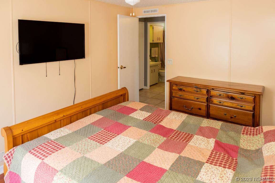 106 Charles Street Edgewater, FL 32141 - Photo 43 of 89 a bedroom with a bed and a flat screen tv