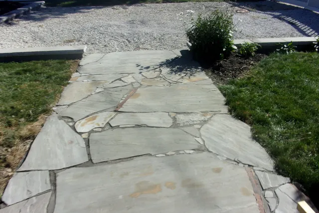 a front view of a house with garden space and sitting area