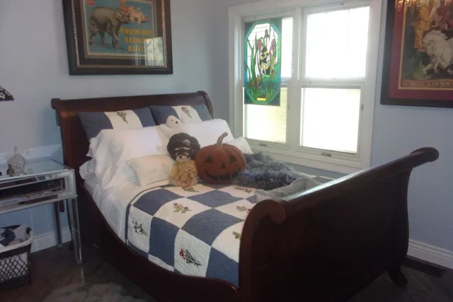 a bed sitting in a bedroom next to a window