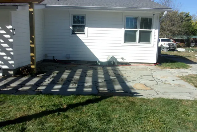 a view of a house with backyard and sitting area