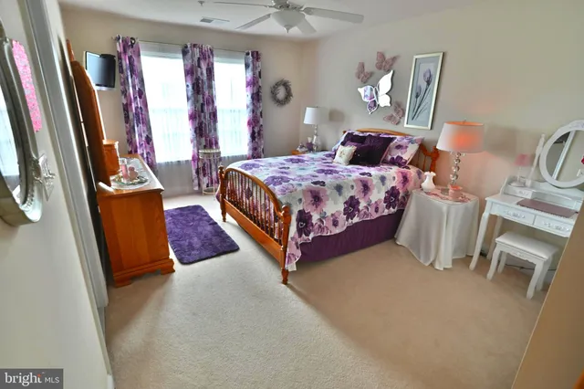 a bedroom with a bed and dresser with wooden floor