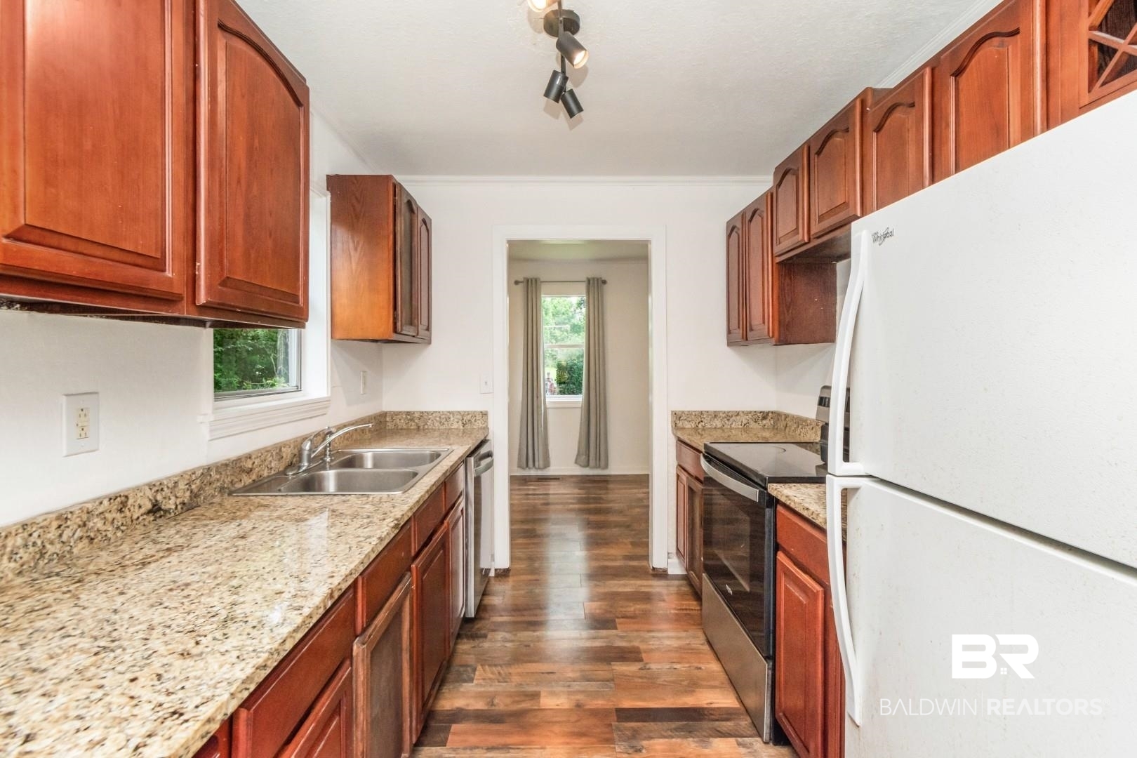 2905A McFarland Road, Unit F Mobile, AL 36695 - Photo 13 of 29 Galley kitchen featuring wood-finish flooring, granite countertops, wood cabinetry, a stainless steel oven/range, and a dual basin stainless steel sink