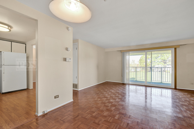 1114 Springinsguth Road, Unit 2A Schaumburg, IL 60193 - Photo 8 of 19 a view of an empty room with a window and wooden floor