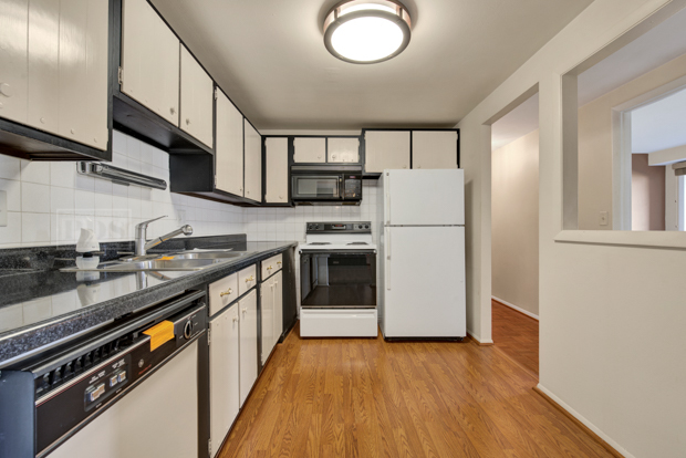 1114 Springinsguth Road, Unit 2A Schaumburg, IL 60193 - Photo 9 of 19 a kitchen with stainless steel appliances granite countertop a stove a refrigerator and a microwave