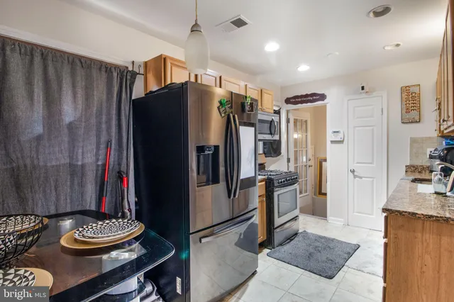 a kitchen with stainless steel appliances granite countertop a refrigerator and a stove