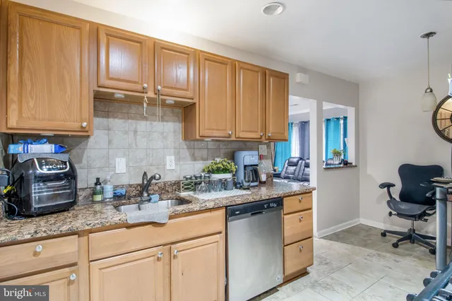 a kitchen with granite countertop a sink a stove and cabinets