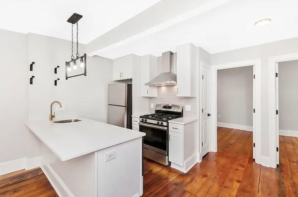 a kitchen with stainless steel appliances a sink stove and refrigerator