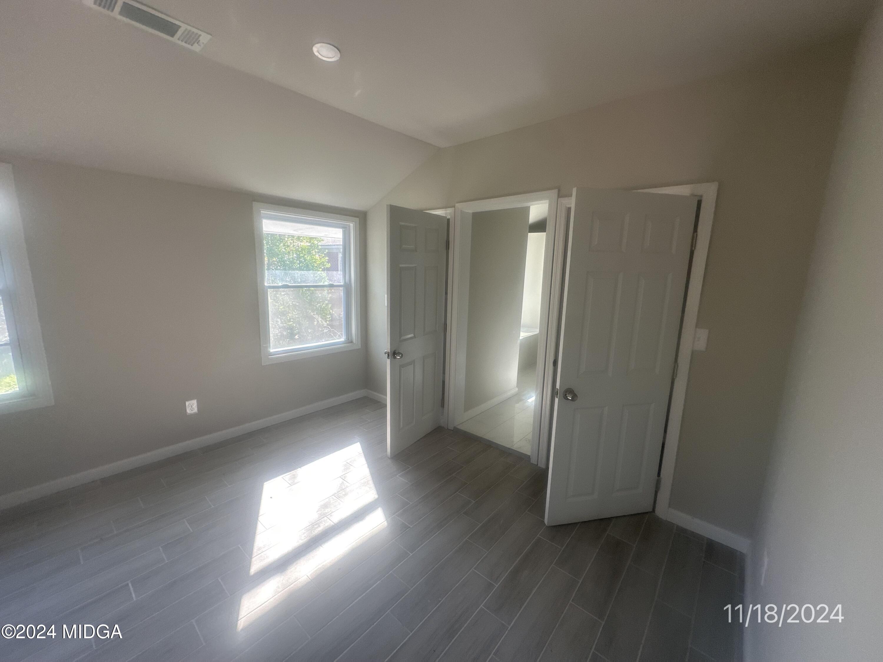 735 Maynard Street Macon, GA 31217 - Photo 6 of 9 an empty room with wooden floor and windows