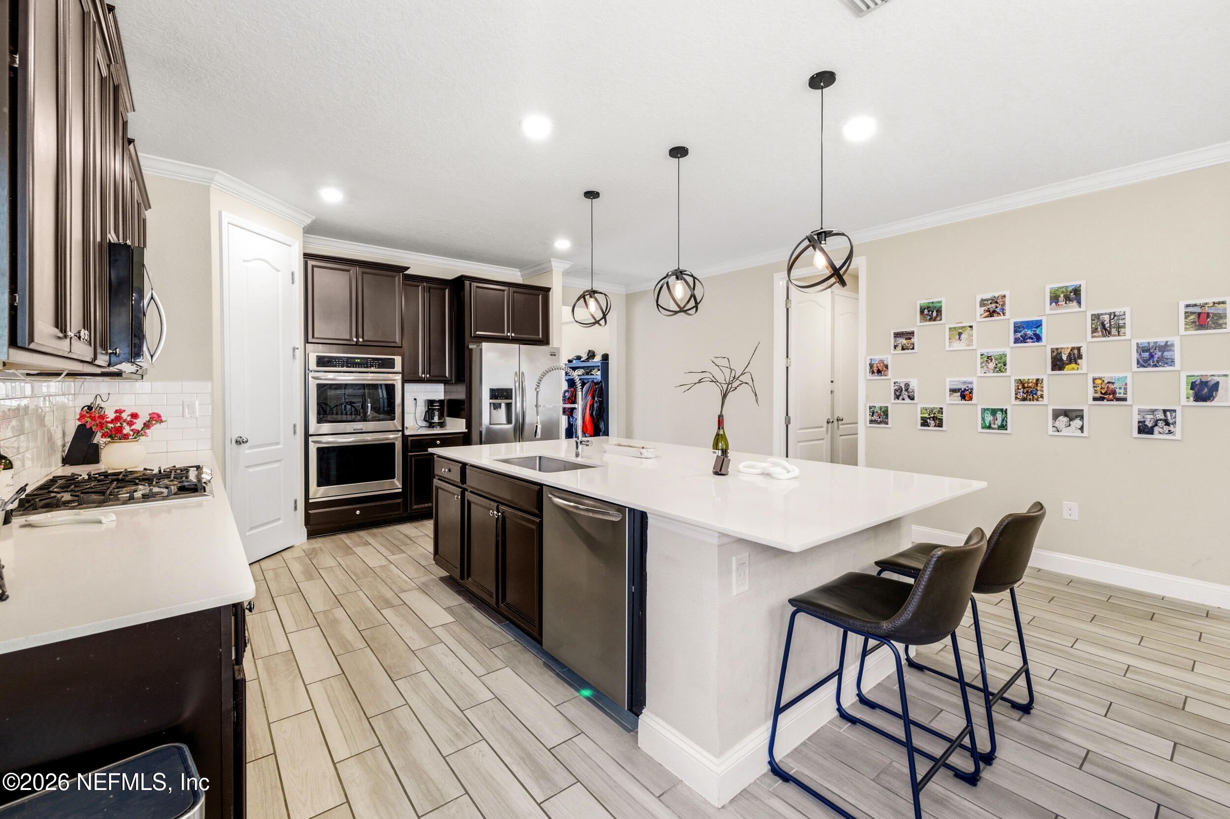 113 Howell Court St. Augustine, FL 32092 - Photo 27 of 63 a kitchen with stainless steel appliances kitchen island granite countertop a sink a stove and a wooden floors