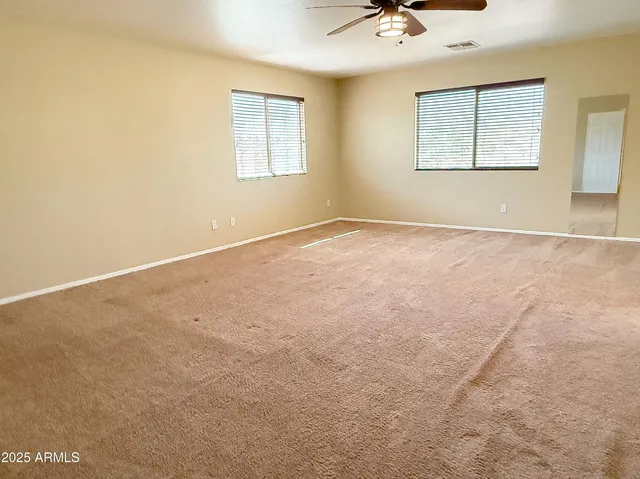 an empty room with a window and a ceiling fan