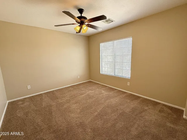 an empty room with a window and a fan