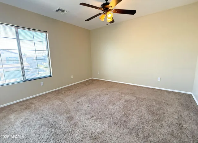an empty room with windows and fan