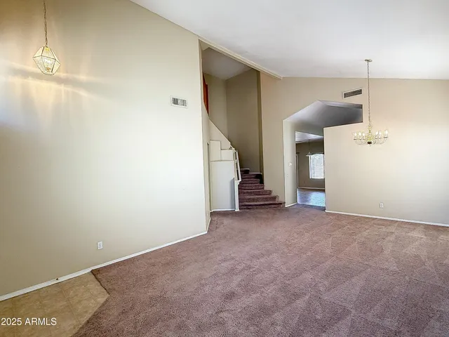 an empty room with staircase and white walls