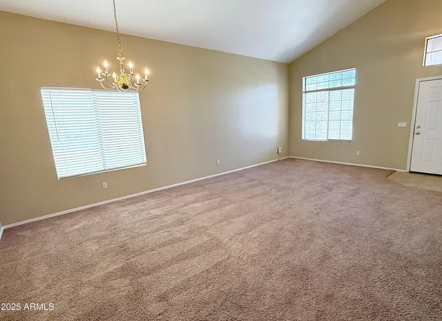 an empty room with windows and chandelier