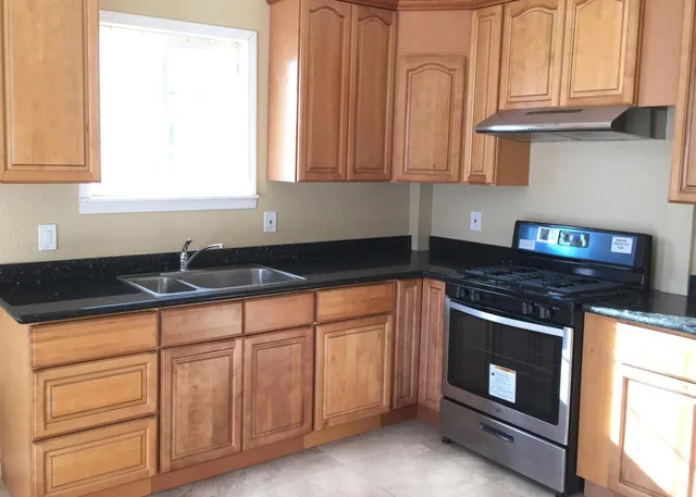 a kitchen with stainless steel appliances granite countertop white cabinets and a stove