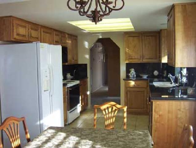 10107 Zier Road Yakima, WA 98908 - Photo 3 of 7 a kitchen with stainless steel appliances granite countertop a refrigerator a stove a sink a washer and dryer with wooden floor