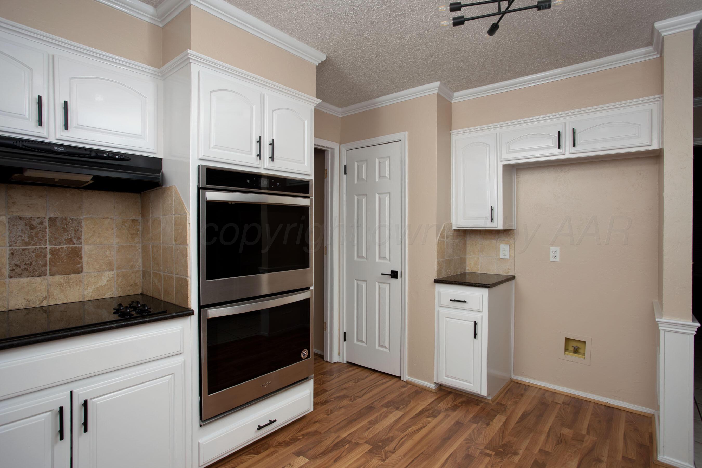 3529 Cinderella Lane Amarillo, TX 79121 - Photo 15 of 33 a kitchen with white cabinets and black appliances