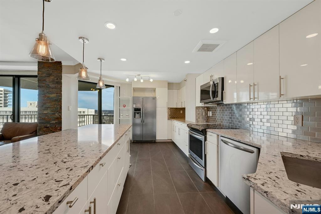 245 Prospect Avenue, Unit 12B Hackensack, NJ 07601 - Photo 12 of 33 a large kitchen with kitchen island granite countertop a large counter top stainless steel appliances and cabinets