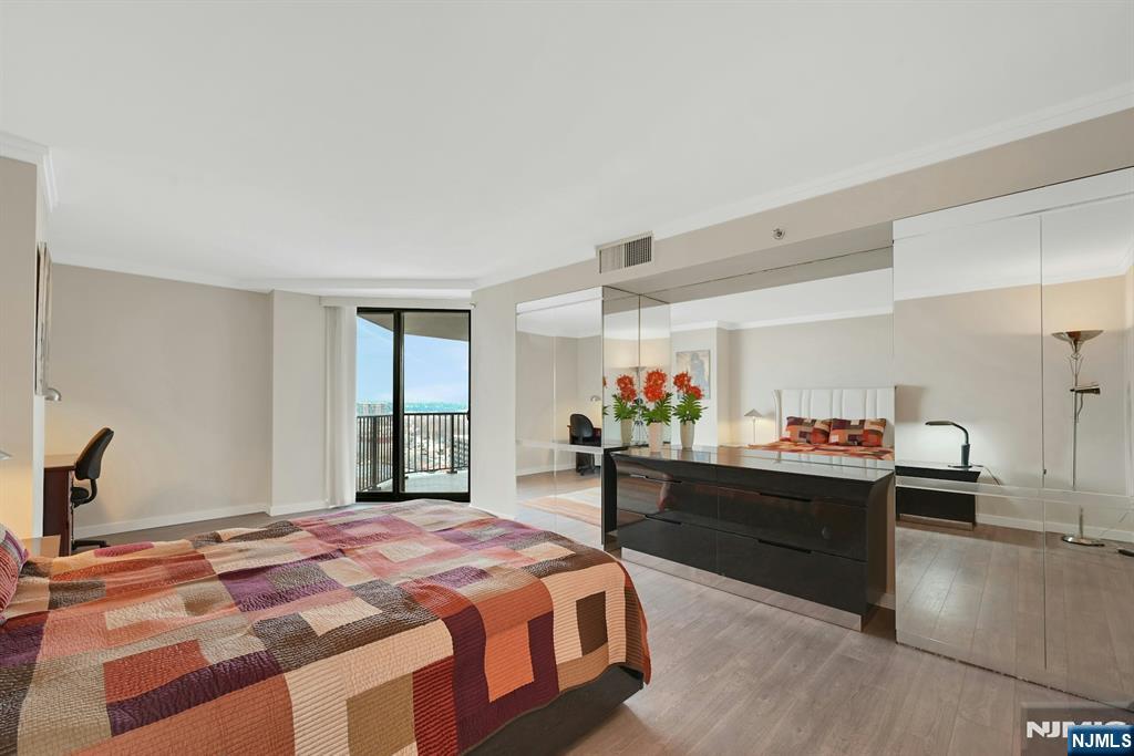 245 Prospect Avenue, Unit 12B Hackensack, NJ 07601 - Photo 16 of 33 a bed room with a bed and a desk