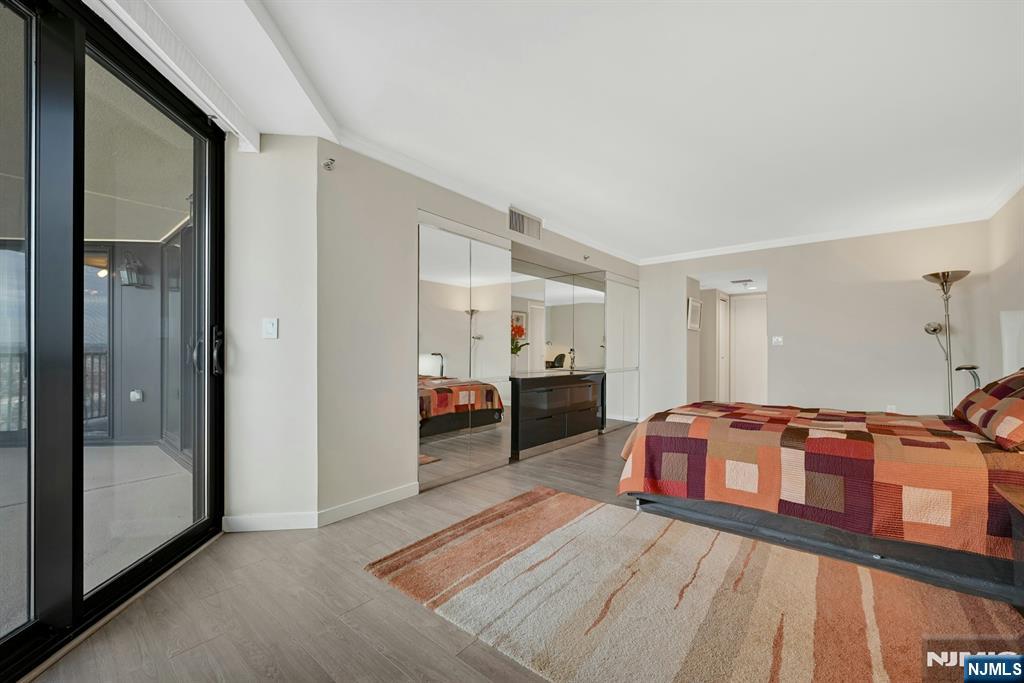 245 Prospect Avenue, Unit 12B Hackensack, NJ 07601 - Photo 17 of 33 a bedroom with furniture and a mirror