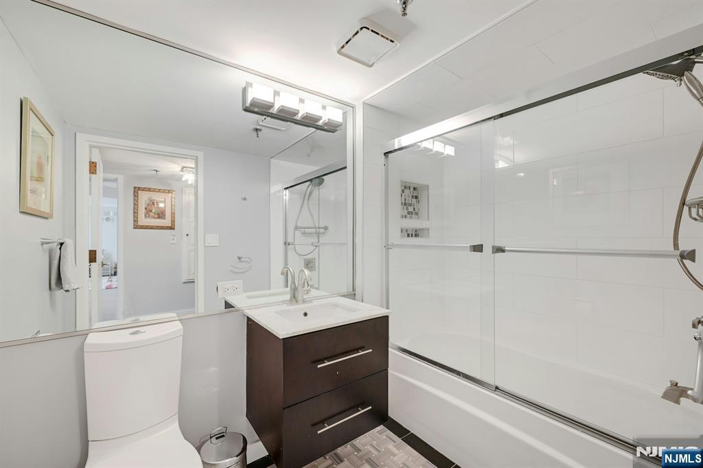 245 Prospect Avenue, Unit 12B Hackensack, NJ 07601 - Photo 23 of 33 a bathroom with a sink a toilet a mirror and shower