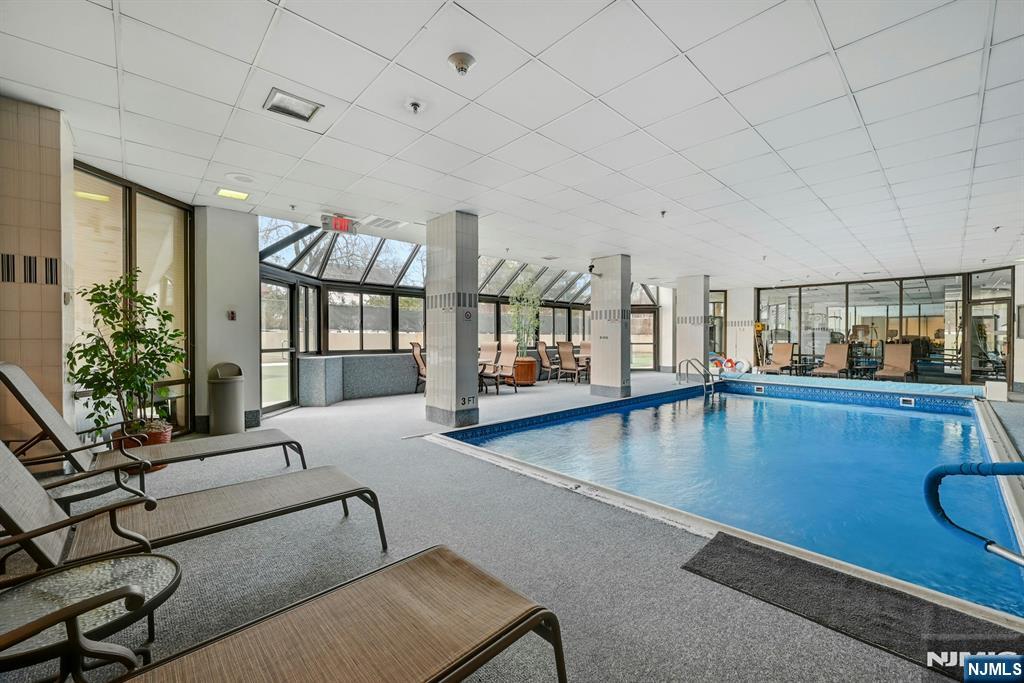 245 Prospect Avenue, Unit 12B Hackensack, NJ 07601 - Photo 28 of 33 a living room with furniture pool table flat screen tv and windows