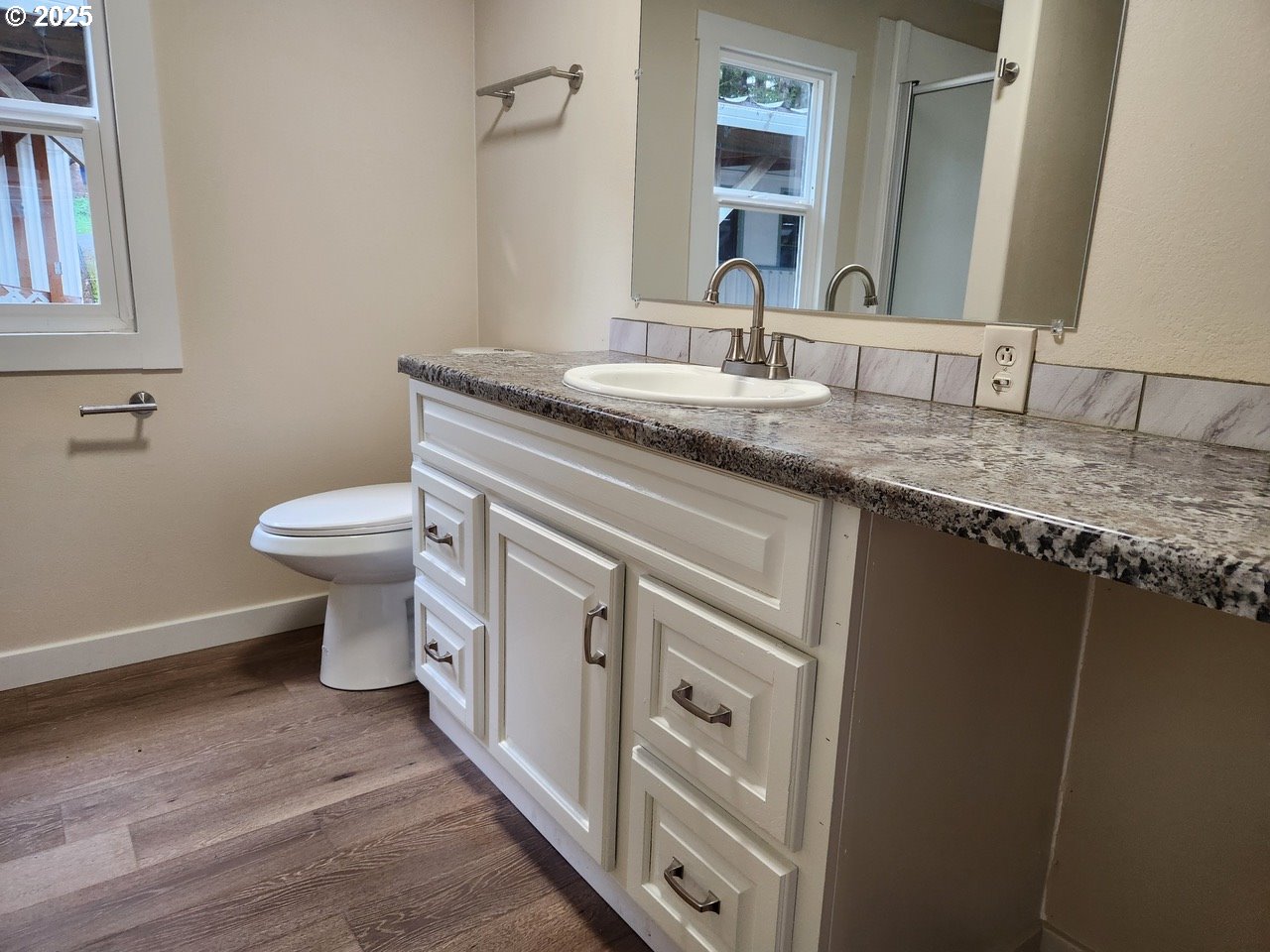 6310 Highway 101, Unit 16 Otis, OR 97368 - Photo 13 of 21 a bathroom with a granite countertop toilet sink and mirror