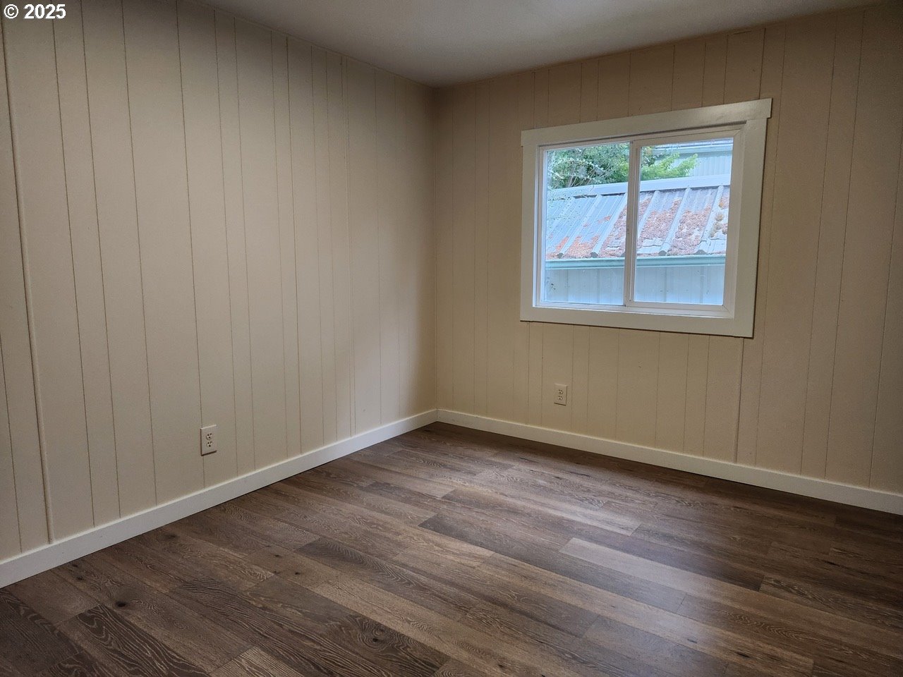6310 Highway 101, Unit 16 Otis, OR 97368 - Photo 15 of 21 a view of an empty room with wooden floor and a window