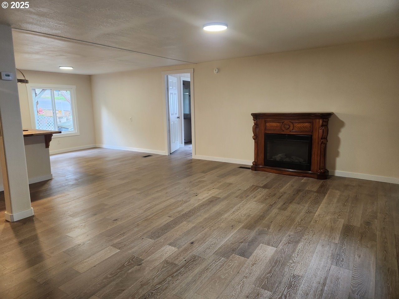 6310 Highway 101, Unit 16 Otis, OR 97368 - Photo 8 of 21 a view of empty room with wooden floor and fireplace